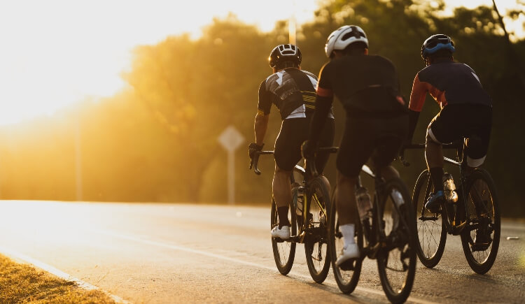 A group of cyclists cycling along a road