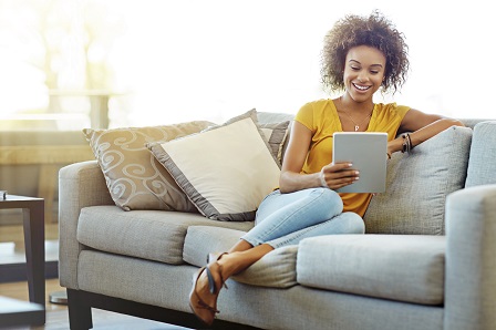 A person sitting on their sofa reading